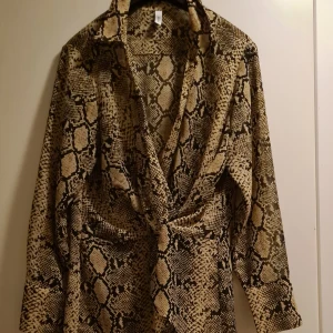 46 - En fin blus sparsamt använd. Omlott i midjan.