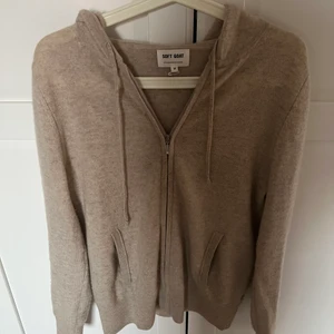 Zip hoodie Kashmir - En ljus beige zip hoodie i kashmir. Säljer pga att den inte kommer till användning. Den ser ganska mörk ut på bild men den är ljusare i verkligheten. Nypris 2000kr.