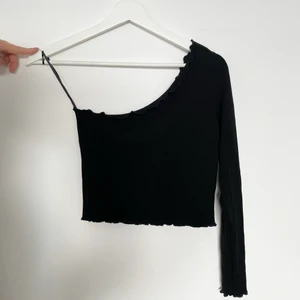 Festlig enarmad topp - En supersnygg ”cropped” topp från ASOS. Har enbart testat tröjan därmed nyskick. Fina virvel detaljer på kanterna och ärmen.