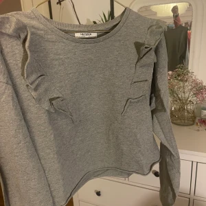Tröja - Grå tröja med volang från Zara i storleken M, 70kr + frakten man själv får stå för 