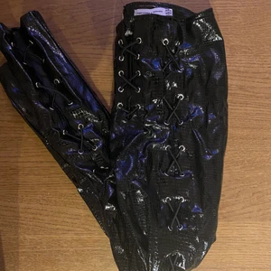 Lack byxor med snörning Missguided  - Missguided lackbyxor i ormskinnsimitation. I bra skick. Snörning är hela benet. Katt i hemmet. Kan mötas upp i Uddevalla om ej så står köparen för frakten. 