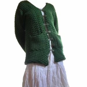 Grön Stickad Tröja - Grön tröja köpt på Beyond Retro. Den har ett vitt sammetstyg på insidan och stickat grönt på utsidan. Tror det är en tröja men den är väldigt tjock så passar bra som jacka också. Väldigt fina knappar men en fattas:,( jag kan sy dit knappen igen om nån är intresserad av att köpa den