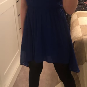 En mörk blå klänning  - Det är en 152, den är 99kr och köptes för 115 . Den är längre där back och kort där fram. Den är för 12 år men passar även för äldre ordrar.