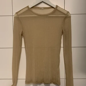 Glittrig topp  - Glittrig topp från Gina tricot. Köparen står för frakt 