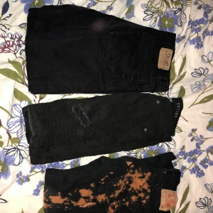 Svarta jeans i olika storlekar  - Svarta jeans Baggy jeans Motorcykel jeans som är ripped Blekta svarta jeans