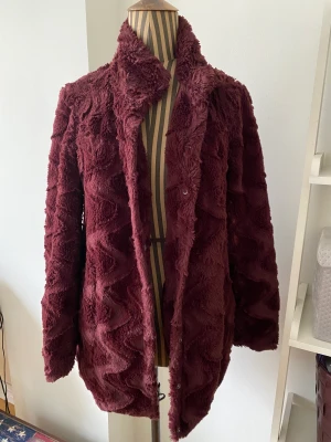 Härlig vinröd jacka XS - Jättefin jacka från Vila i vinröd fuskpäls. Storlek XS men har fungerat bra på mig som är S. Bra skick, inte använd särskilt mycket.