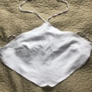 Ett vitt triangelformat linne med öppen rygg