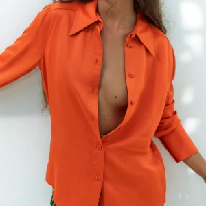 Röd satinskjorta - Röd satinskjorta från Zara. Skjortan ser ut som den på första bilden men med den röda färgen på bild 2. Aldrig använd, kan skicka fler bilder om så önskas