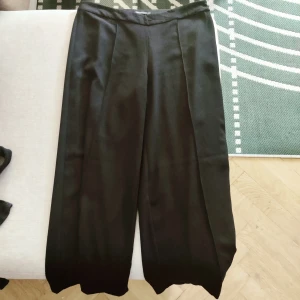 Vida kostymbyxor - Mycket vida och luftiga kostymbyxor i gott skick. Kort modell, slutar ovanför ankeln. Av märket Stylein.