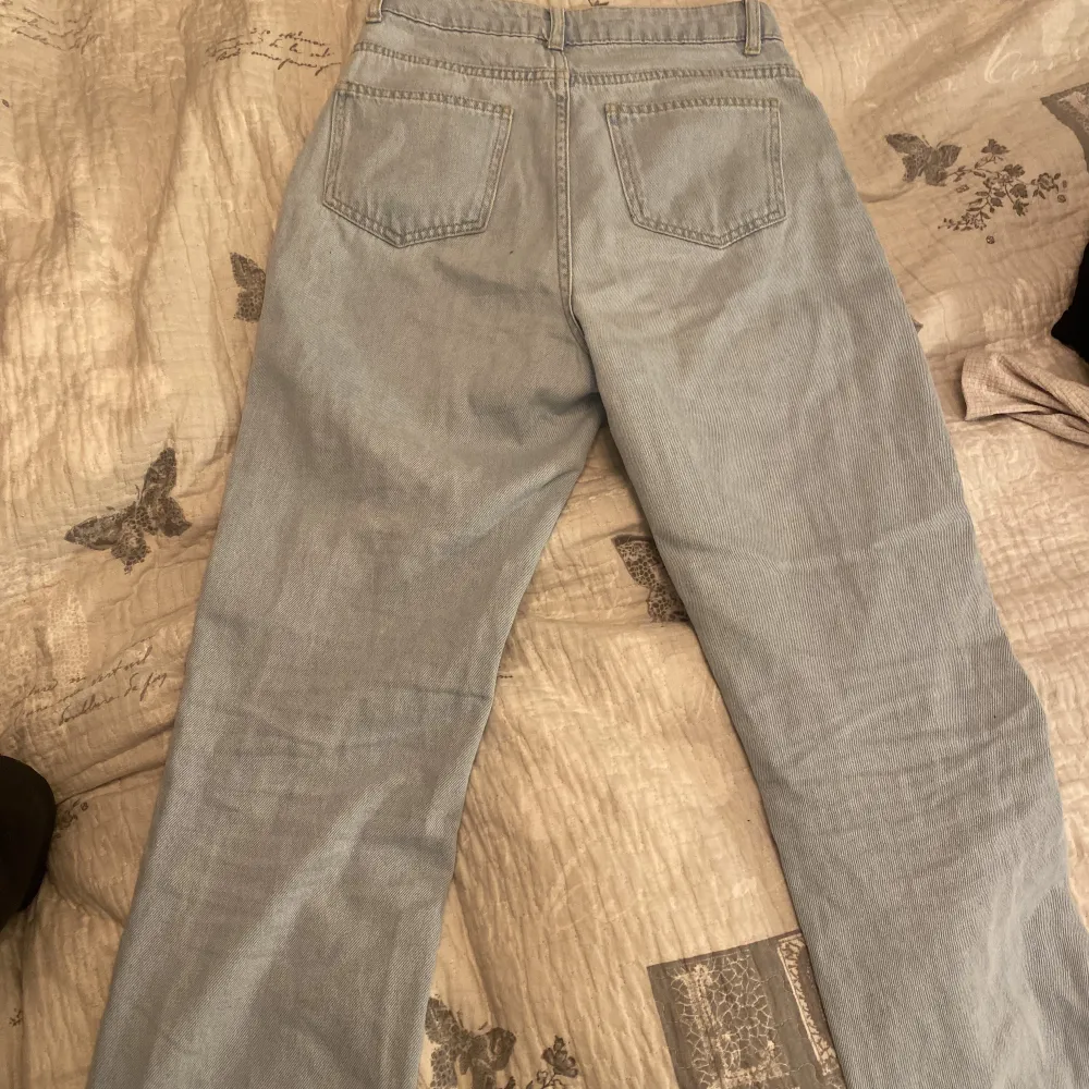Ett par blåa högmidjade jeans från na-kd,andvända några gånger,knappar istället för dragkedja . Jeans & Byxor.