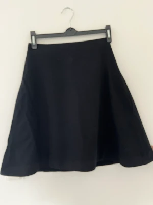 Acne kjol - Acne kjol i A-linjeformad kort kjol. Två dragkedjor i guld på baksidan.