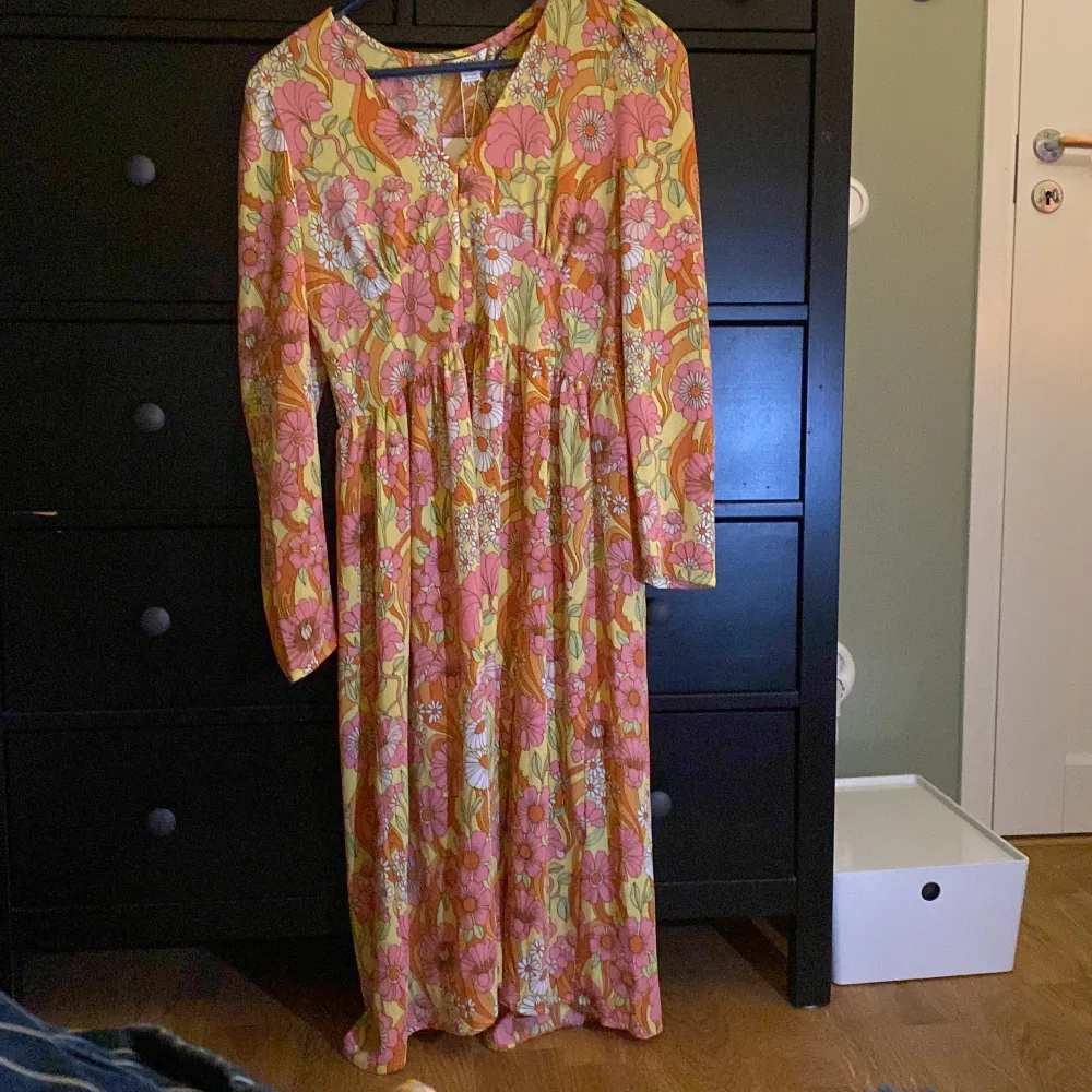 En lång klänning med blommor  från monki. Aldrig använd, prislappen kvar. Storlek 40, funkar för M och L. Klänningar.