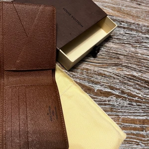 Louis Vuitton - Aldrig använd Louis Vuitton Multiple Wallet. inköpt på Louis Vuitton butiken på Champs-Elysée i Paris. Dustbag och kartong tillkommer. Byten kan ev vara intressant. 