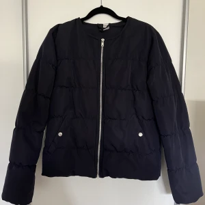 Mörkblå jacka  - Mörkblå kort ”puffjacka” från H&M. Storlek 38 och i väldigt bra skick.