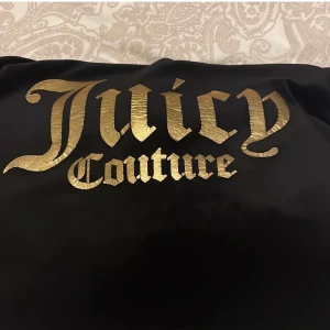 Juicy couture tröja - Säljer min svara Juicy couture tröja med guldig text. Pågrund av att den inte kommer till användning. Den är i storlek 14-15 år (164-170) men passar mindre och större. Jag köpte den för 650 kr och den är i bra skick. DU FÅR FÖRESLÅ PRIS.