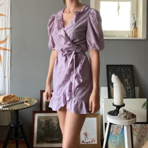 Sommarklänning  - Fin småblommig omlott sommarklänning med knytning och volang. Frakt tillkommer.