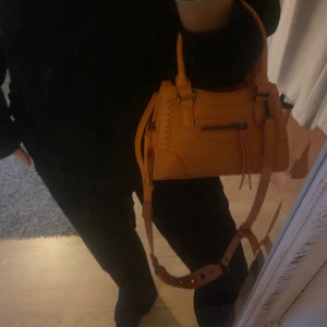 Orange crossbody väska - En helt ny ”small crossbody bag” från ginatricot som är slutsåld online. Bandet är justerbart och man får plats med vad som behövs i väskan, lagom storlek. Nypris 399kr och aldrig använd 💕hör av er för frågor eller fler bilder!