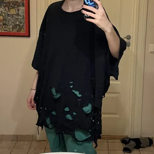 Svart uppriven t-shirt  - En svart t-shirt med en mängd uttöjda hål nertill. Oanvänd och i fint skick. Skriv privat för fler bilder eller vid frågor!