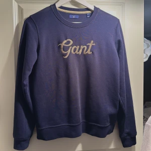 Gant tröja - Marinblå gant tröja med guld broderi. Knappt använd