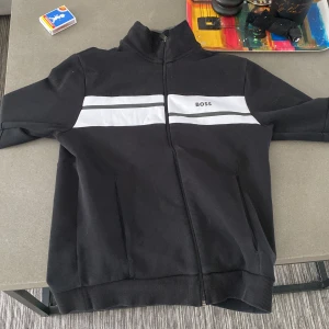 Hugo boss zipp - Jag säljer min Hugo boss tröja pga att jag ej har någon användning av den.  Den är XS men passar som S. Ny pris 2000kr