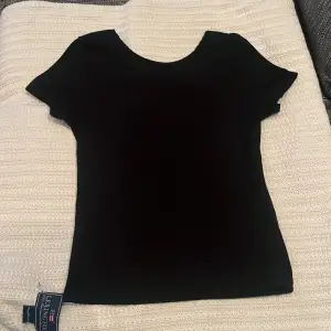 En svart, tight och ribbad T-shirt. Använd ett fåtal gånger.💕