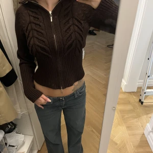 Stickad kofta  - Stickad kofta med dragkjedja i brunt.