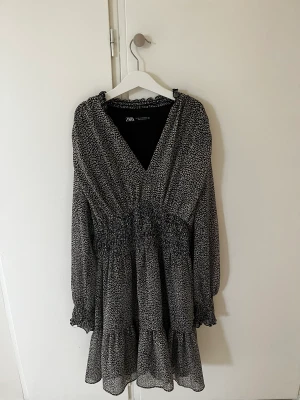 ZARA klänning  - Jätte fin klänning från zara i storlek XS. Hör av er om ni har frågor eller fler bilder!!!! Köp direkt för 200kr den är svart med vita ”leopard fläckar” på och små svaga guldiga ränder!😇