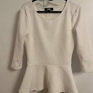 en vit långärmad tröja med en liten volang, den är lite kortare i armarna och har ett typ rutigt mönster, köparen står för frakten💞