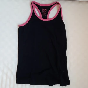 Svart linne i st XS - Svart linne med rosa kanter. Det står att det är storlek 134/140 men strechig, jag som 15 åring kan ha det och uppskattningsvis skulle jag säga att den är mer som en XS