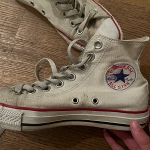 Vita converse  - Vita converse  Använda  Storlek 38 Har en röd fläck på framsidan samt lite utsuddat converse märke annars sköna och bra Skriv för mer bilder eller om du är intresserad av att köpa Frakt inkluderas ej i priset