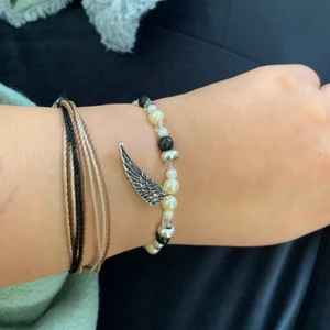 armband, smycke - fint armband med en vinge i silver, lätt att sätta på handleden då den glider över handen. små silver detaljer. frakt kostar 12kr