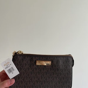 Michael kors väska  - Liten nätt väska ifrån Michael kors med guldkedja.  Jag har aldrig använt väskan där av är prislappen kvar. Säljes till någon som har mer användning för den ☺️ Köparen står för frakten! Skickas via PostNord ” skicka lätt ” med spårbar frakt! 