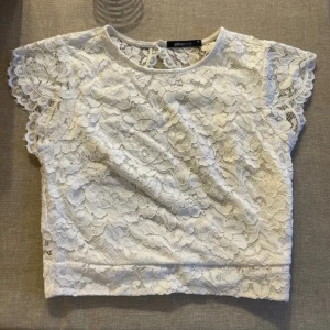 Vit spetstopp med öppen rygg - Jag säljer denna kortärmade crop top från Gina Tricot, som är öppen i ryggen. Jag säljer den då den inte kommit till användning. Perfekt till student till exempel❤️‍🔥