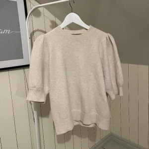 Stickad tröja vero moda - Söt stickad tshirt med lite puffärm från veromoda, i beige. Den blir nopprig ju mer man använder den men superlätt att ta bort med noppborttagare! 