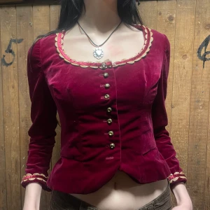 Sammetjacka - Vinröd sammetsjacka.  Längd: 48cm Bredd: 36x2 En knapp fattas och några pärlor, annars i gott skick!