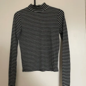 Randig polotröja - Randig polotröja med tight passform. Köparen står för eventuell frakt 