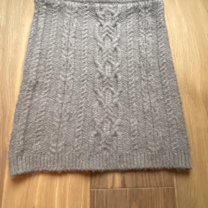 Stickad kjol -  En stickad rosa som är medellång 