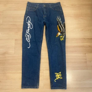 lågmidjade Ed Hardy Jeans - super coola ed hardy jeans med örn på. Köpta på plick och är lite missfärgade på botten. De är lite lågmidjade och sitter lite baggy. Skriv för bild