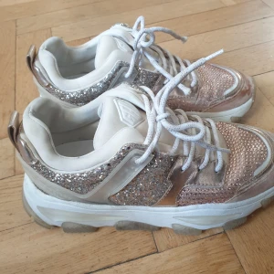 Kurt Geiger stlk 38 - Jättesköna Kurt Geiger sneakers i stlk 38. Pärlor och glitter över mestadels hela skon. Kan behöva en uppputsning. 1200 kr 