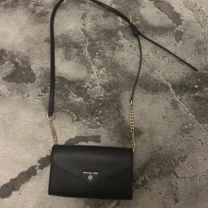 Micheal Kors väska - En kuvertväska från micheal kors, super fin till vardags och middag då man kan ta av banden till! Använd 1-2 gånger, basically helt ny.