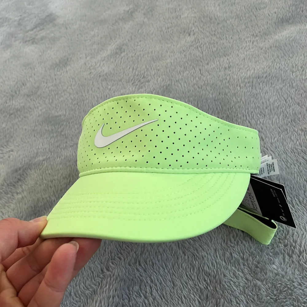 Halvkeps eller keps med öppen toppperfekt till tennis, padel eller golf. Helt oanvänd med lapp kvar. Neongrön från Nike. Accessoarer.