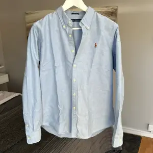 Ljusblå Polo Ralph Lauren skjorta i felfritt skick. Skjortstorlek 14 slimfit, sitter som S slimfit. Nypris runt 1700kr, säljes då den ej kommer till användning.