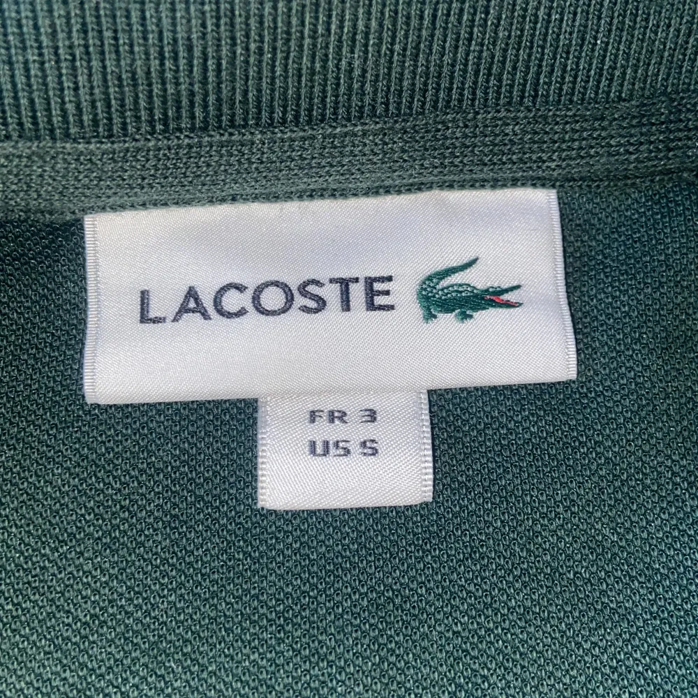 En mörk grön Lacoste pike aldrig använd.. Skjortor.