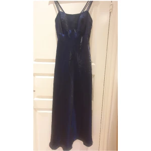 Mörkblå balklänning - Vacker shimrigt mörkblå balklänning, ca storlek M/L  (38-42). Längd: 122 (ej inriktat med banden) Byst: ca 37x2. Korsad rygg. Köpt second hand men aldrig använd, inga defekter❣️🎀