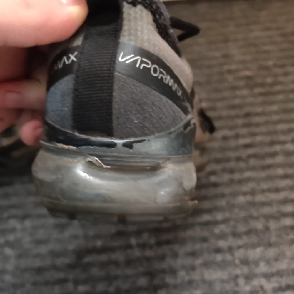 Nike vapor max storlek 39. Grå färg. Använda och ett hål (se bild 3). Hålet går att fixa lätt men skorna har blivit för små. Skick 7/10. Skor.