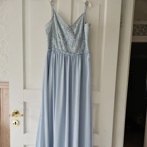 Ljusblå balklänning  -  Fin blå balklänning i skönt material med fina detaljer. Använd 1 gång under en kväll, så i mycket bra skick. Sitter skönt på. Strl M normal i strl . 