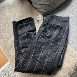 Kostymbyxor - Svarta byxor med vita ränder från Shein. Knapp tillkommer. Oanvända. Storlek S