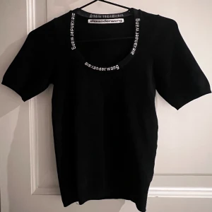 T-shirt  - Svart T-shirt med text runt kragen. Kan ej hitta en stl på den, men skulle nog chansa på S. 