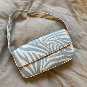 Axelväska - Väska i unikt mönster i blått och vitt jeans-liknande tyg Knappt använd så nyskick 