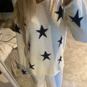 Stickad tröja med stjärnor - Fin stickad tröja som är lite större i modellen och är vit med marinblå stjärnor